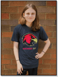 A girl standing in front of a brick wall.