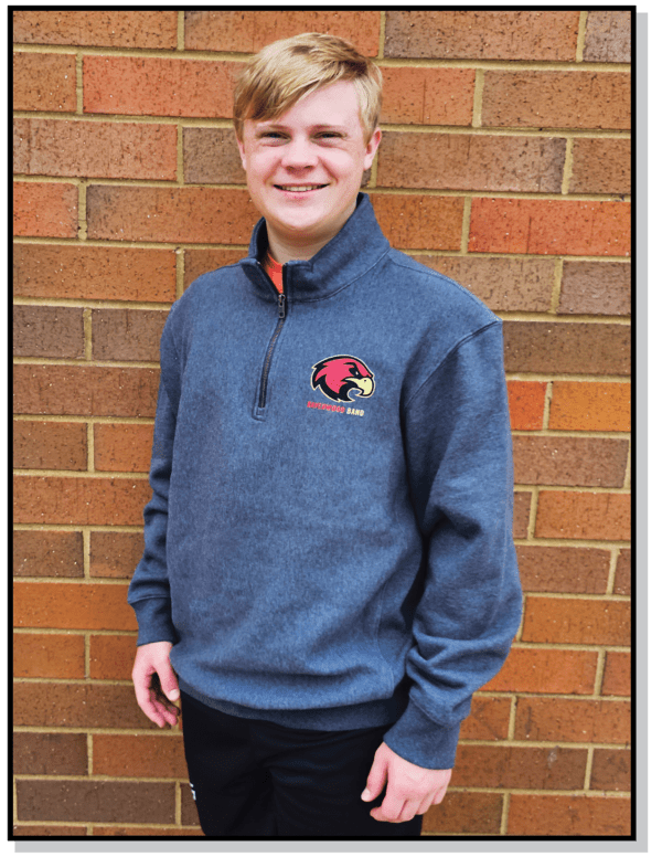 A man standing in front of a brick wall.