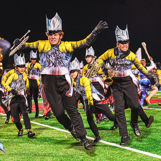 A group of people in costumes marching on the field