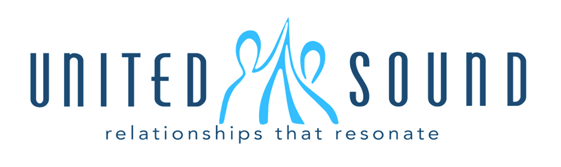 A blue logo of two people standing next to each other.